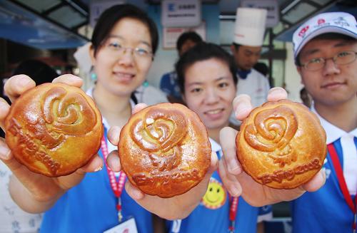 Paralympics volunteers present homemade mooncakes bearing the logo of the Beijing Olympic Volunteers Program at a volunteer service station located in downtown Beijing on Thursday, September 11, 2008. These special mooncakes are gifts for volunteers scheduled for duty during the Mid-Autumn Festival on Sunday. [Photo: Xinhua] 