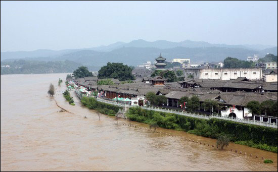 The flood inundated the dykes and dams in Langzhoung City in Sichuan Province on July 17, 2009. Torrential rains and floods have left at least 8 people dead and five missing in south China's Sichuan Province as of 6:00 PM on July 17. [Xinhua]