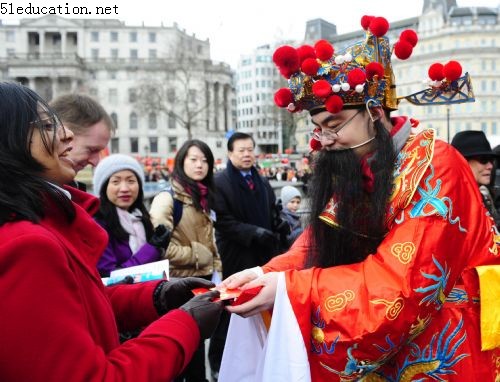 A man dressed up as Money God sends a gift to a woman during a celebration of Chinese Lunar New Year on Trafalgar Square in London, capital of Britain, Feb. 21, 2010. Grand Chinese Lunar New Year celebrations were held in Trafalgar Square, Leicester Square and Chinatown in London on Sunday, providing a spectacular Chinese traditional festival experience to locals and visitors alike. 